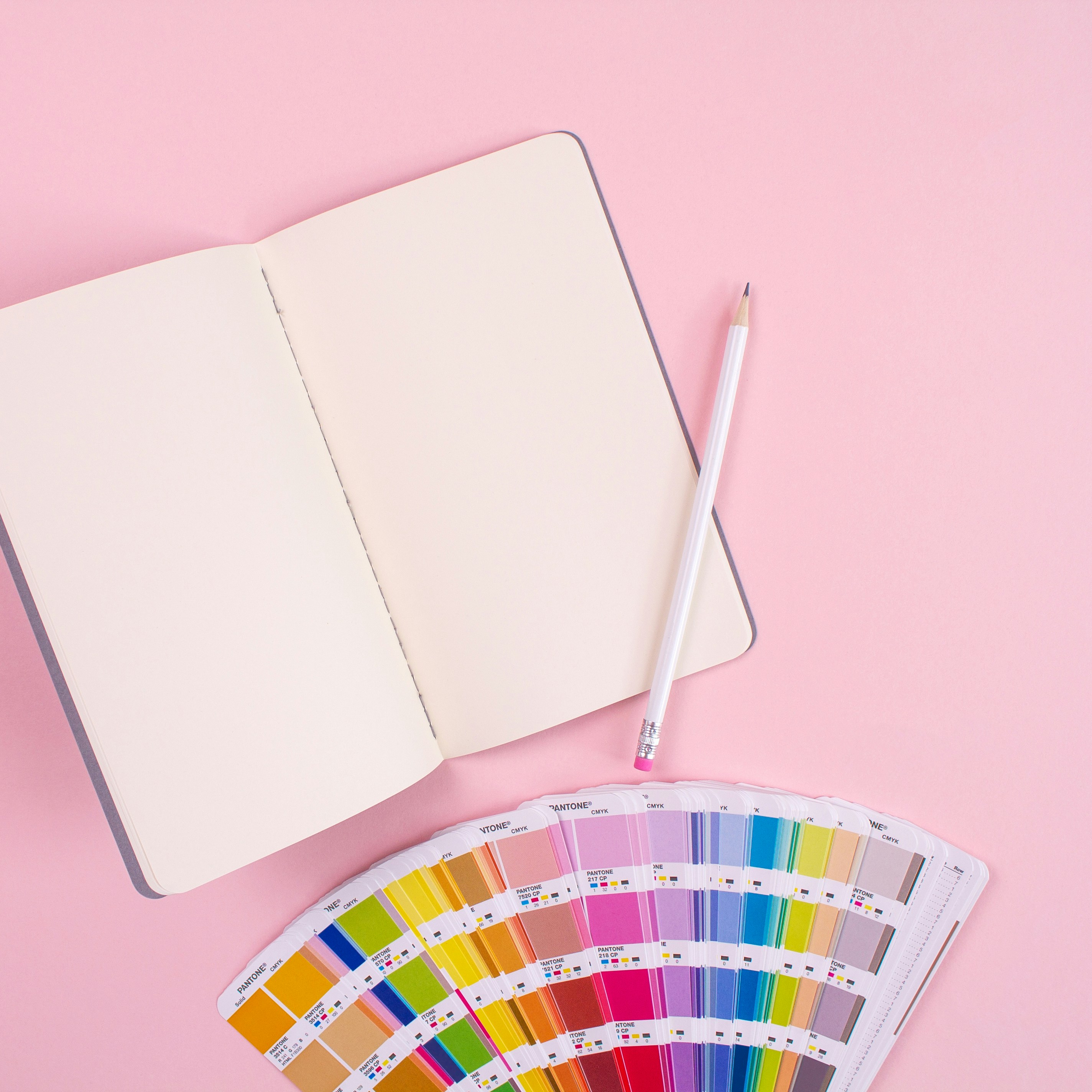 Book with pencil in pink background